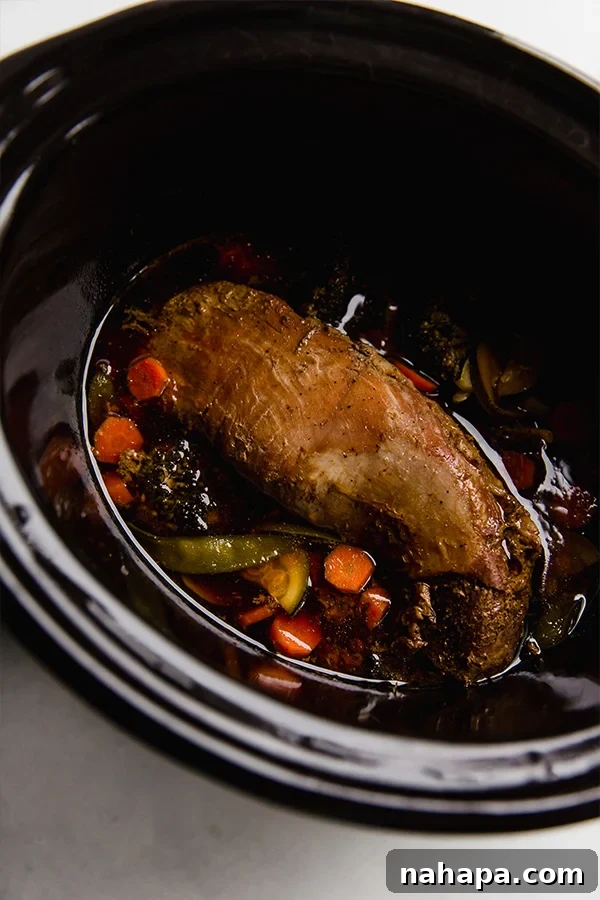 The slow cooker filled with teriyaki pork tenderloin and vibrant vegetables, ready to be cooked to perfection.