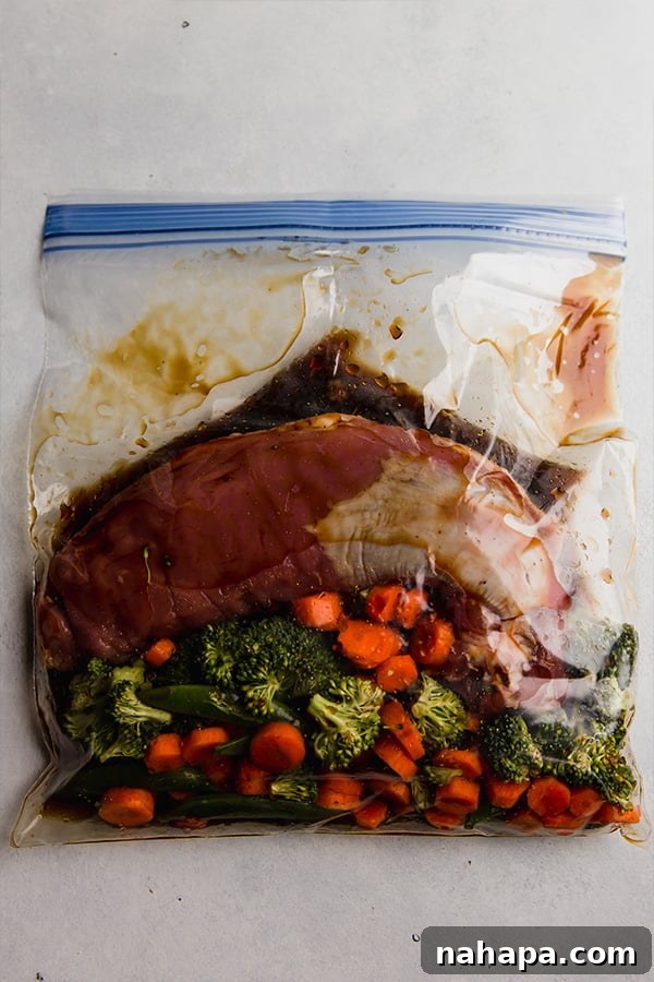 A freezer bag containing the prepped slow cooker teriyaki pork tenderloin and vegetables, ready for future cooking.