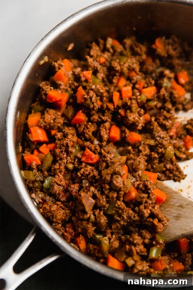 The savory filling cooking in a pot, with ground beef and vegetables.