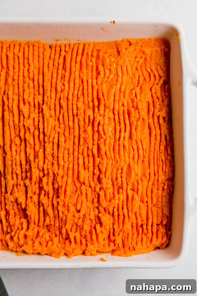 Sweet potato shepherd's pie in a baking dish with a decorative fork pattern on top.