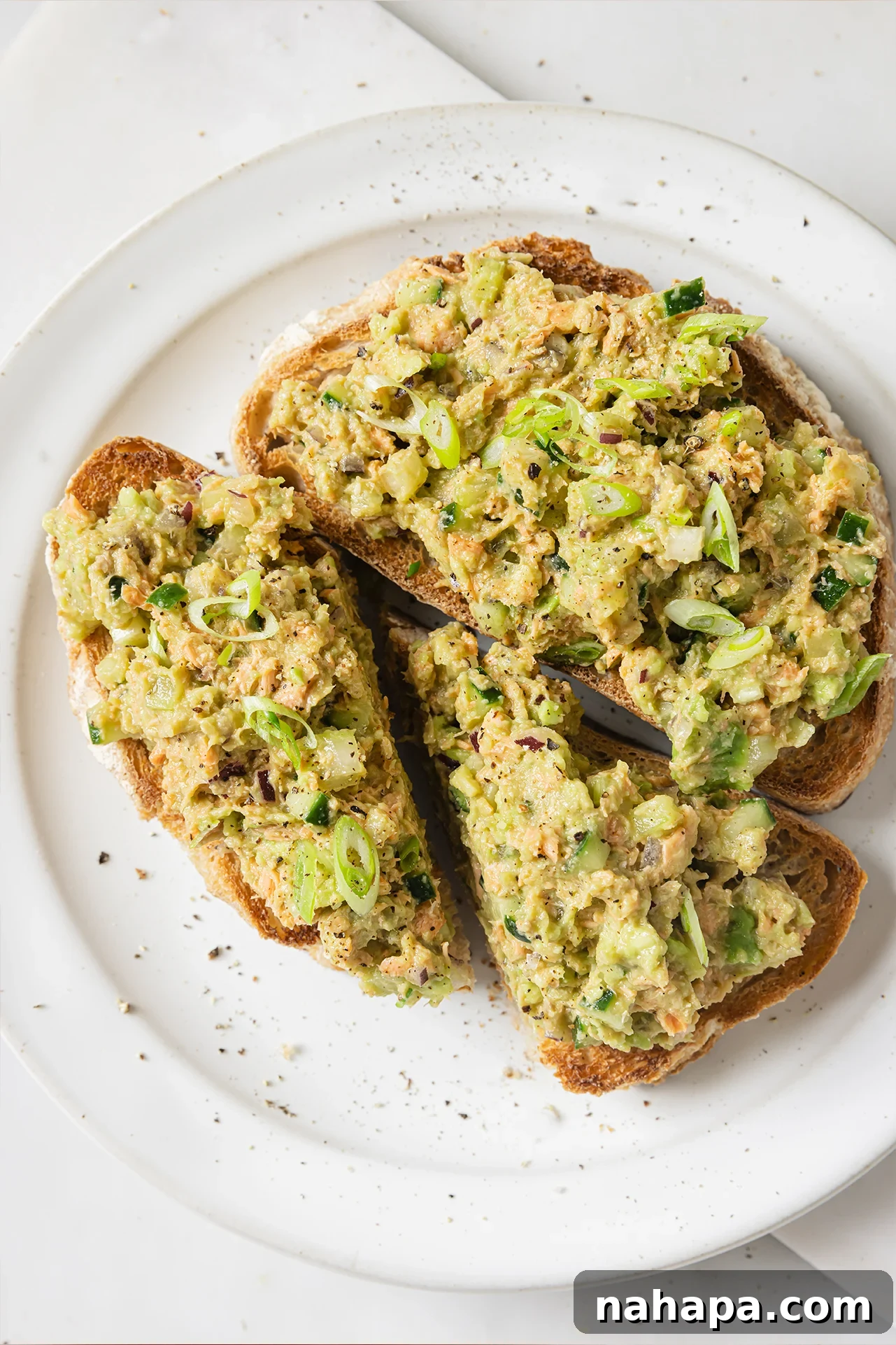 Avocado salmon salad on two slices of toast.