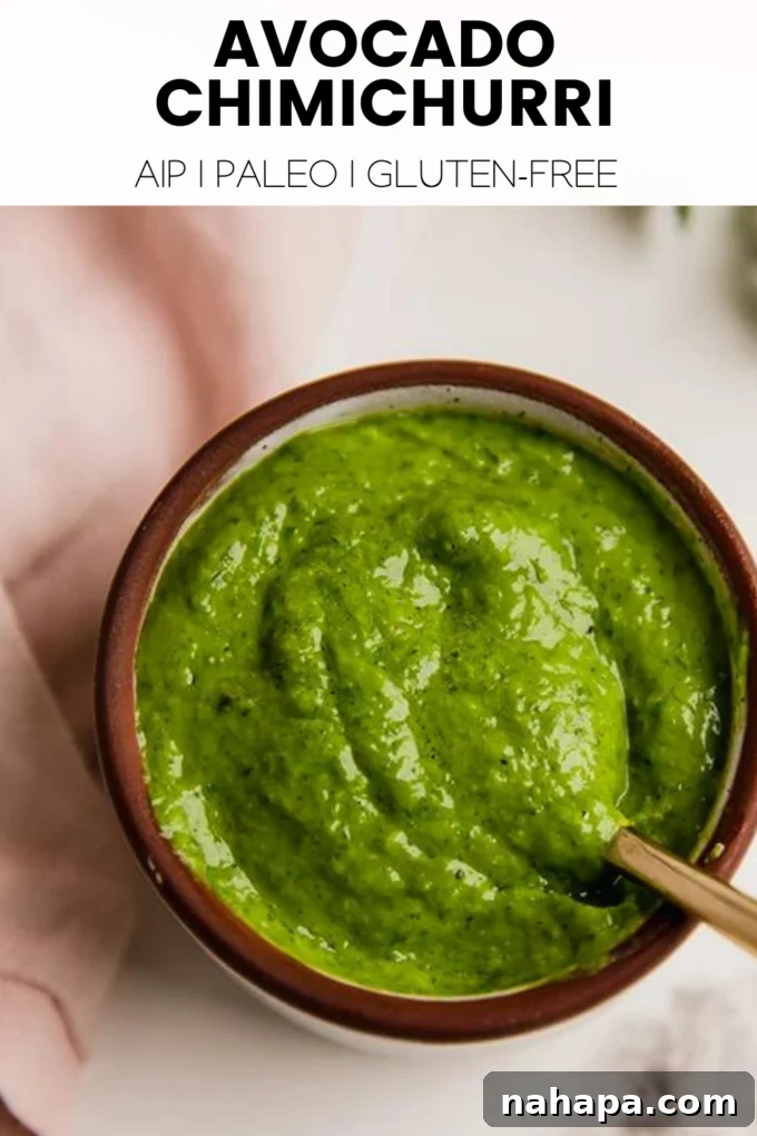 A large serving of avocado chimichurri sauce in a bowl, with fresh herbs around it.