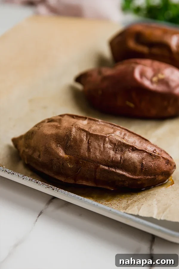 Baked sweet potatoes on a baking sheet.