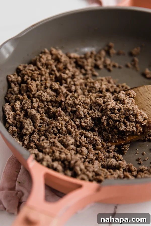 Ground beef browning in a pan.