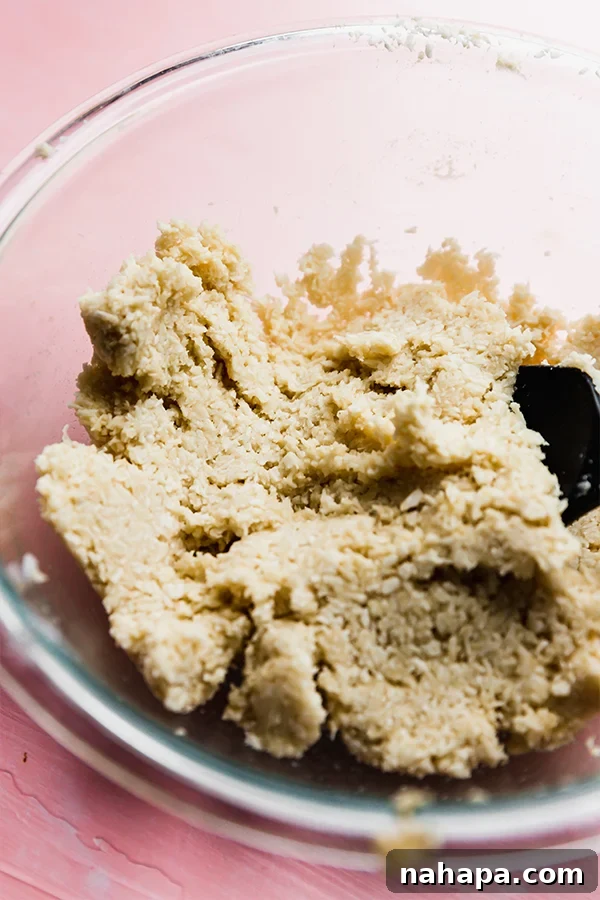 The dough for coconut macaroons in a glass bowl.