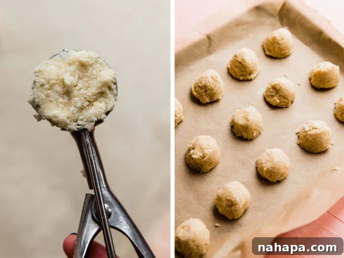 The dough for coconut macaroons scooped onto a baking sheet, ready for baking.