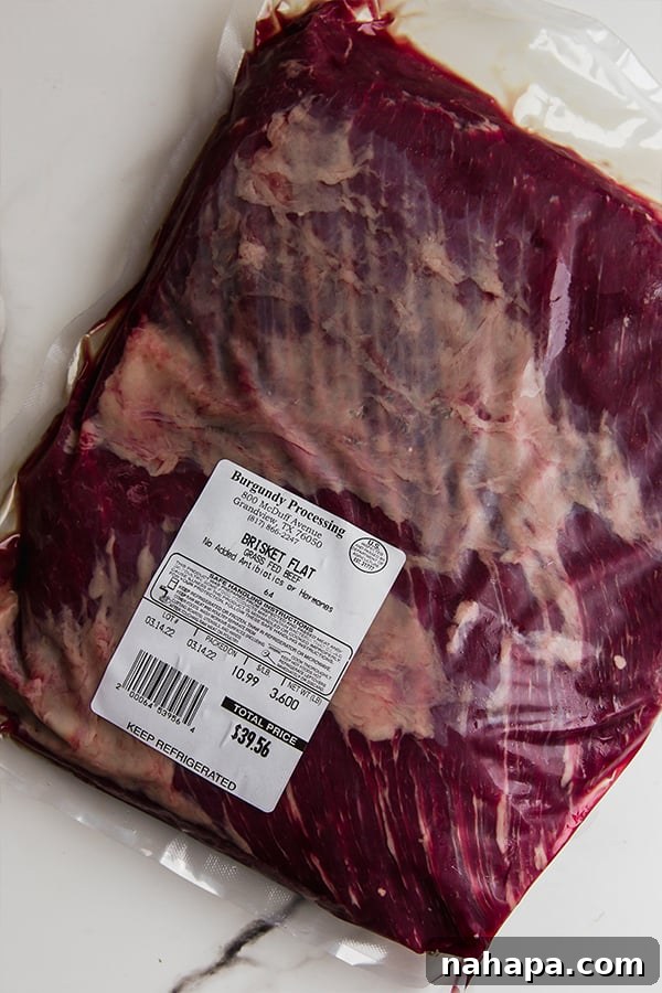 A raw brisket flat, seasoned and ready for searing, showcasing the marbling and fat cap crucial for a moist dish.