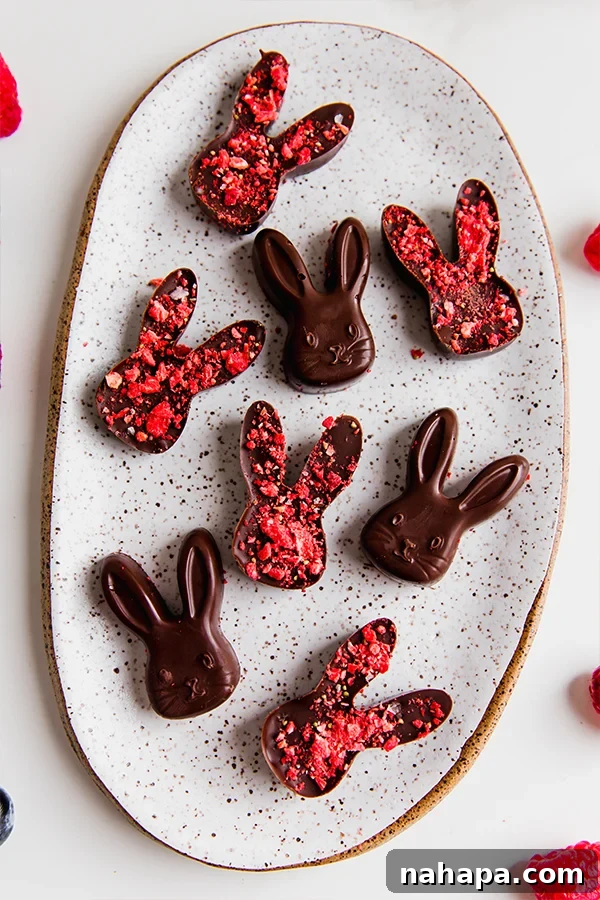 A plate of homemade dairy-free chocolate Easter bunnies, adorned with crushed freeze-dried strawberries.