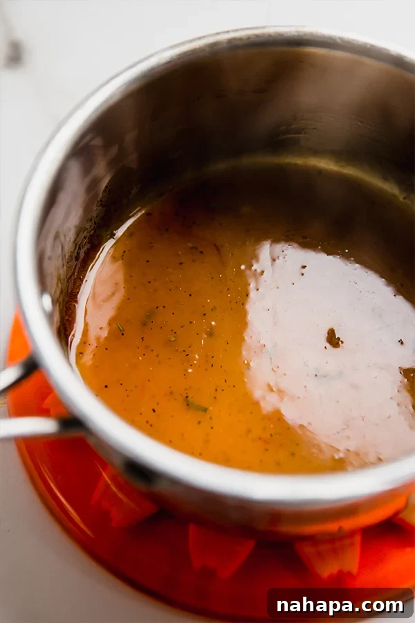 Marinade cooking in a pot on the stovetop to create the glaze.