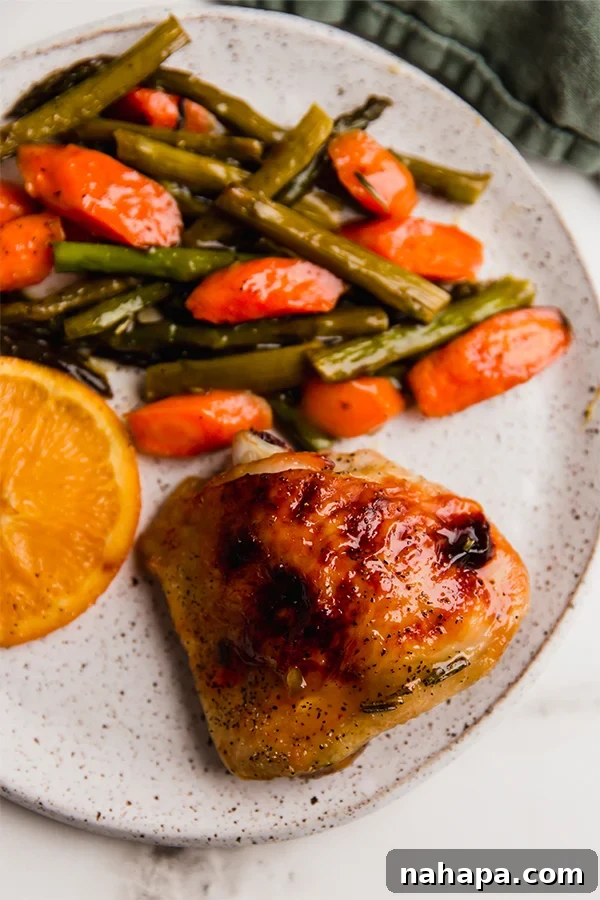 A plate with a serving of citrus glazed chicken and roasted vegetables.