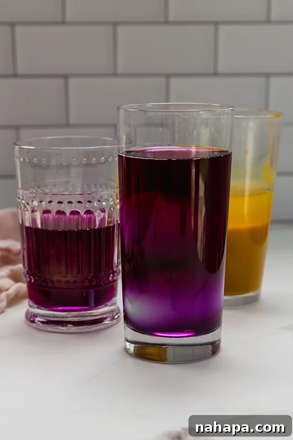Several Easter eggs soaking in different natural dye baths inside clear glasses, showcasing the beginning of their colorful transformation.