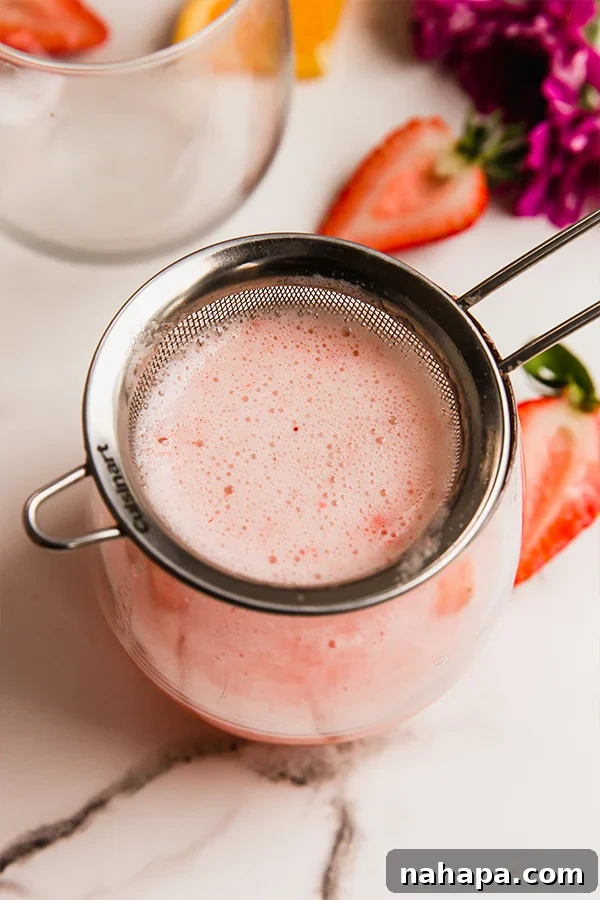 Strawberry Sparkler 4 A cup of strawberry mimosa mocktail, garnished with mint and strawberry slices.