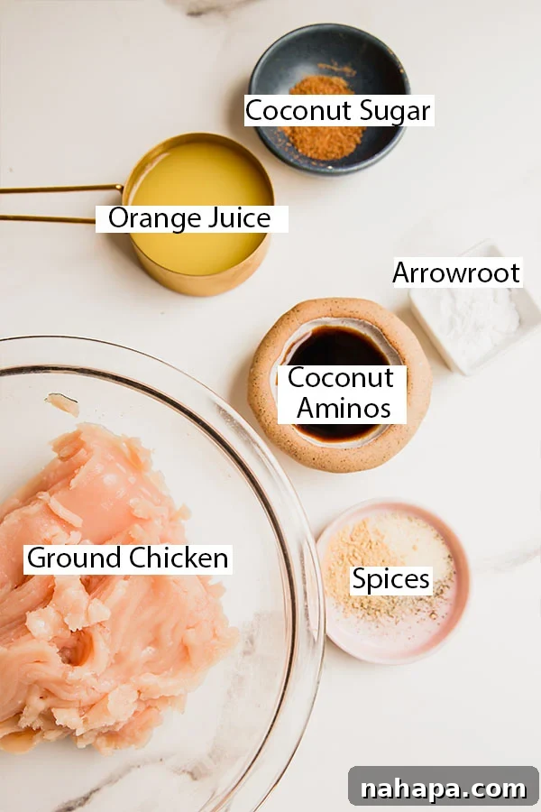Ingredients laid out for making orange chicken meatballs, including ground chicken, spices, orange juice, and other sauce components.