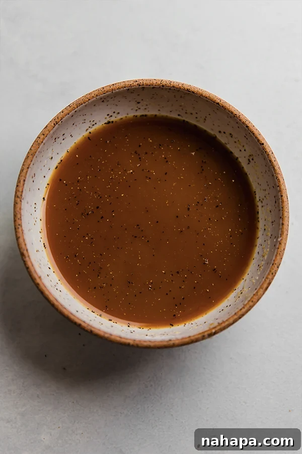 A small bowl containing the orange chicken sauce, showcasing its vibrant color and smooth consistency.