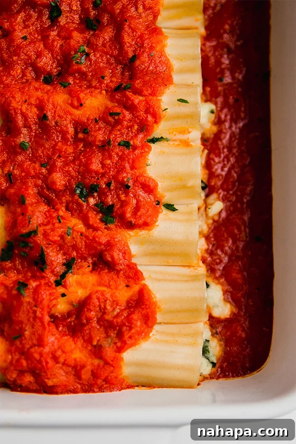 Savory Vegan Cauliflower Ricotta Manicotti Gluten Free 6 A large baking dish brimming with freshly baked gluten-free cauliflower manicotti, garnished with fresh herbs.