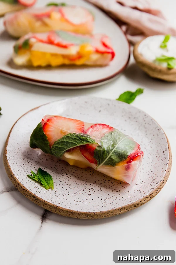 Refreshing Fruit Rice Paper Wraps with Tangy Yogurt Drizzle 6 A beautifully arranged fruit rice paper roll on a simple white plate, ready to be enjoyed as a light and healthy snack or dessert.