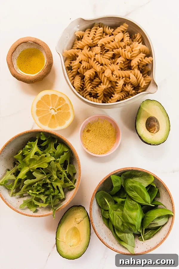 The vibrant ingredients for creamy avocado pesto pasta laid out.