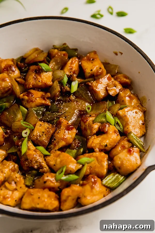 A close-up of a bowl of black pepper chicken stir fry, ready to be eaten.