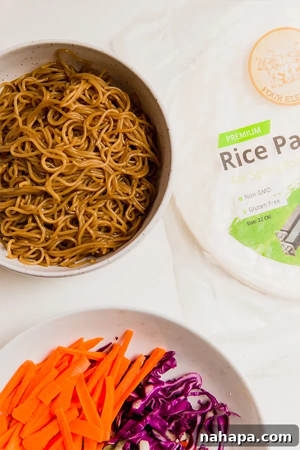 A vibrant selection of ingredients for crispy ramen rice paper rolls, including ramen noodles, fresh vegetables, and seasoning sauces.