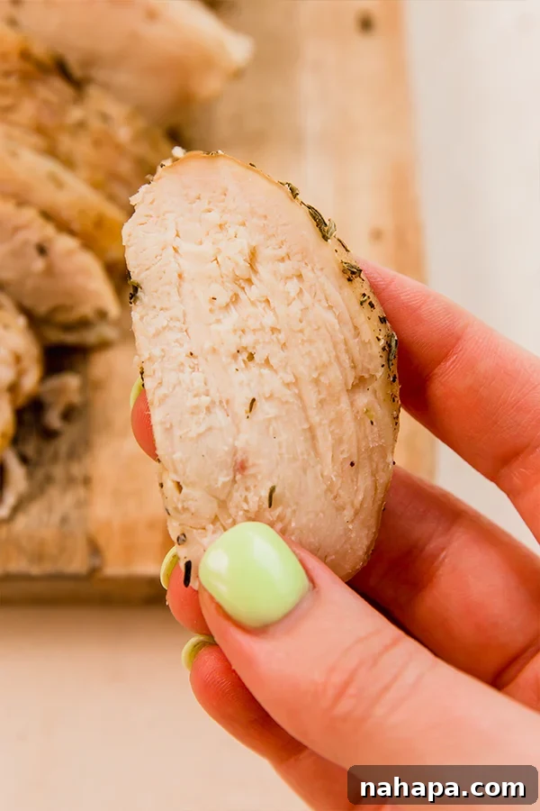 A perfectly sliced piece of homemade chicken lunch meat, showing its tender texture.