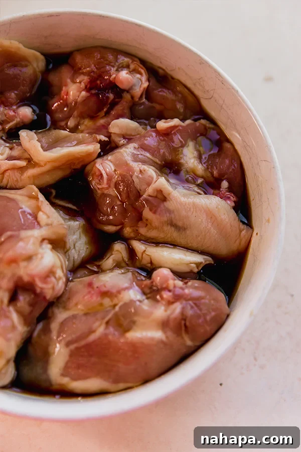 Chicken thighs marinating in a bowl.