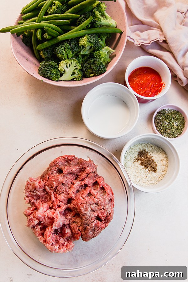 One-Pan Italian Mini Meatloaf & Roasted Vegetables (Gluten & Dairy-Free) 3 A collection of fresh ingredients laid out, including ground beef, green beans, broccoli, various spices, and dairy-free milk, ready for the Italian-Style Mini Meatloaf & Vegetable Sheet Pan recipe.