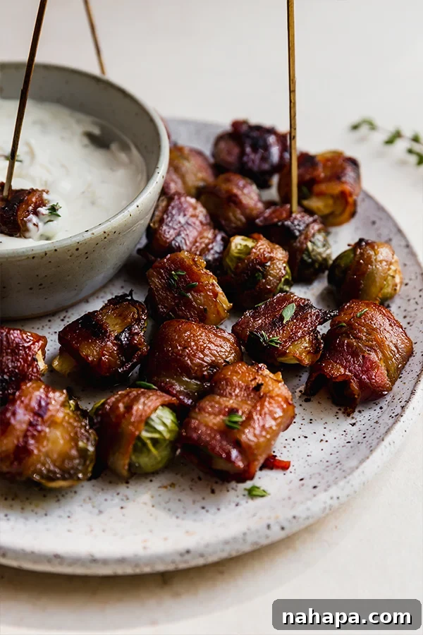 A plate with perfectly cooked, crispy bacon-wrapped Brussels sprouts, ready to be served.