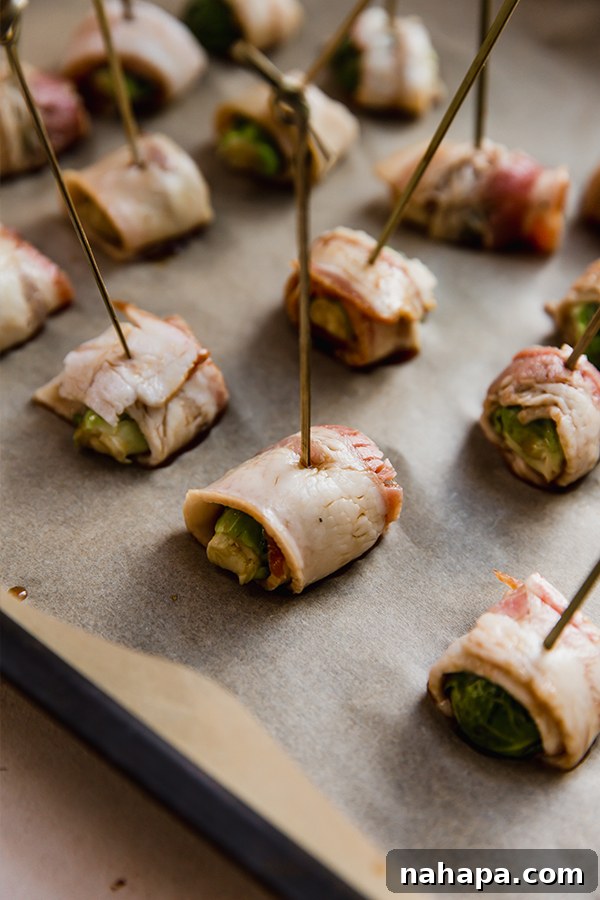 Bacon wrapped Brussels sprouts freshly out of the oven, showing their crispy, caramelized texture.