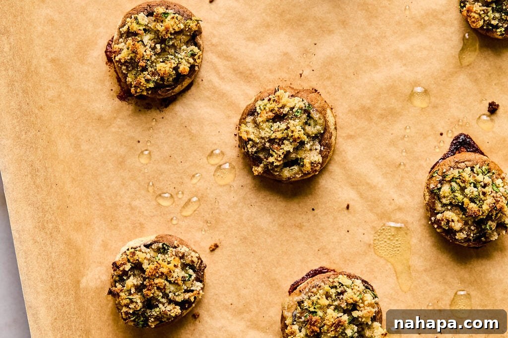 A baking sheet showcasing the beautifully baked stuffed mushrooms, their tops golden and crisp, fresh out of the oven.