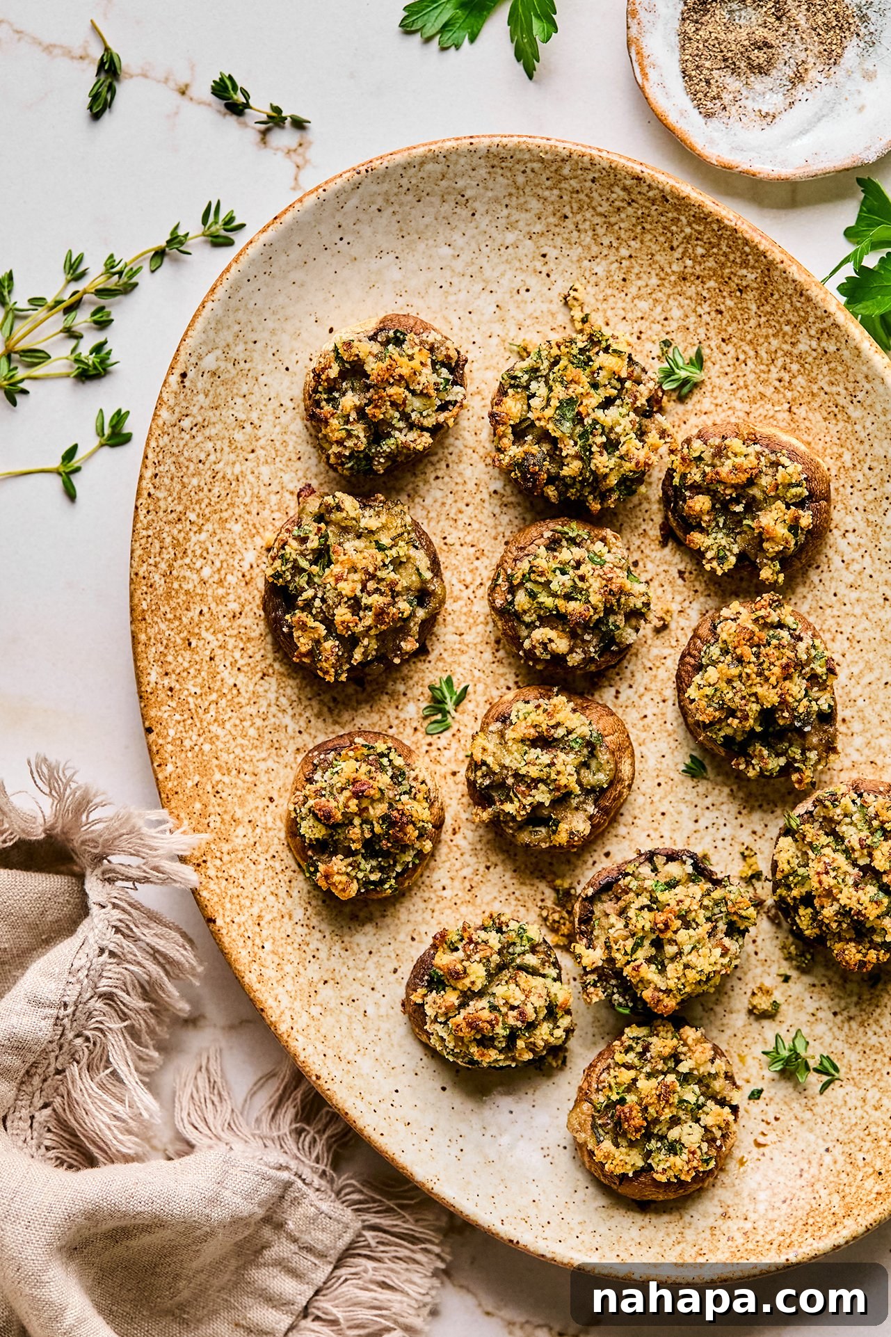 A beautifully presented platter of golden, savory stuffed mushrooms, ready to be devoured at a festive gathering.
