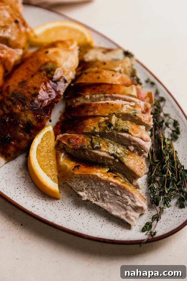 A close-up shot of the perfectly roasted, golden-brown cheesecloth orange herb turkey, ready to be carved.