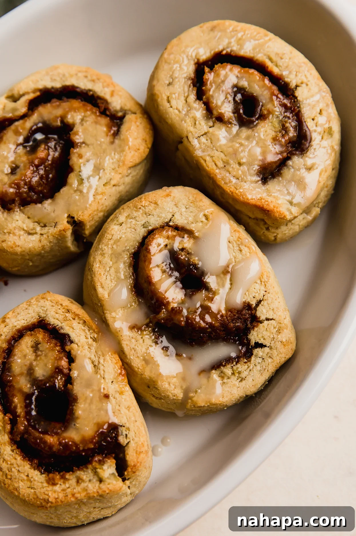 Delicious Gluten Free and AIP Gingerbread Cinnamon Rolls 2 Gingerbread cinnamon rolls in a baking tray.