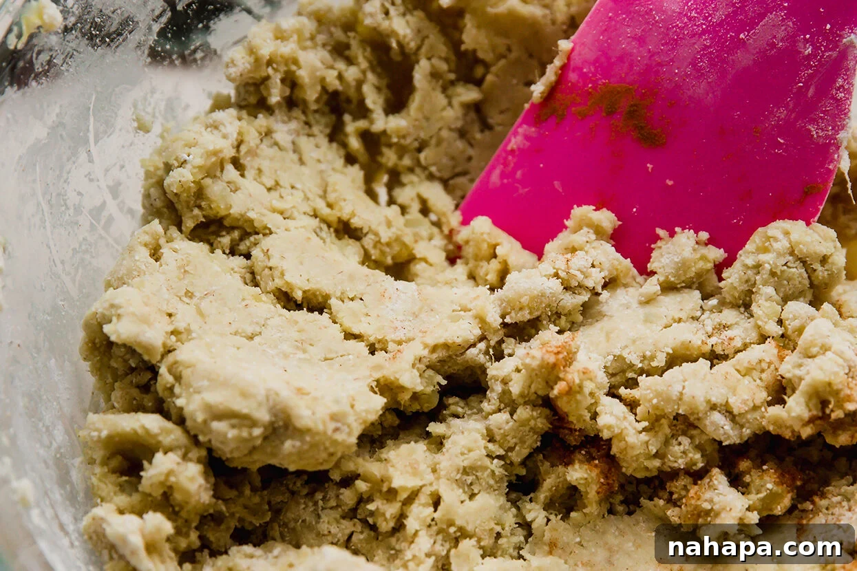 Delicious Gluten Free and AIP Gingerbread Cinnamon Rolls 3 Gingerbread cinnamon roll dough in a bowl with a spoon.