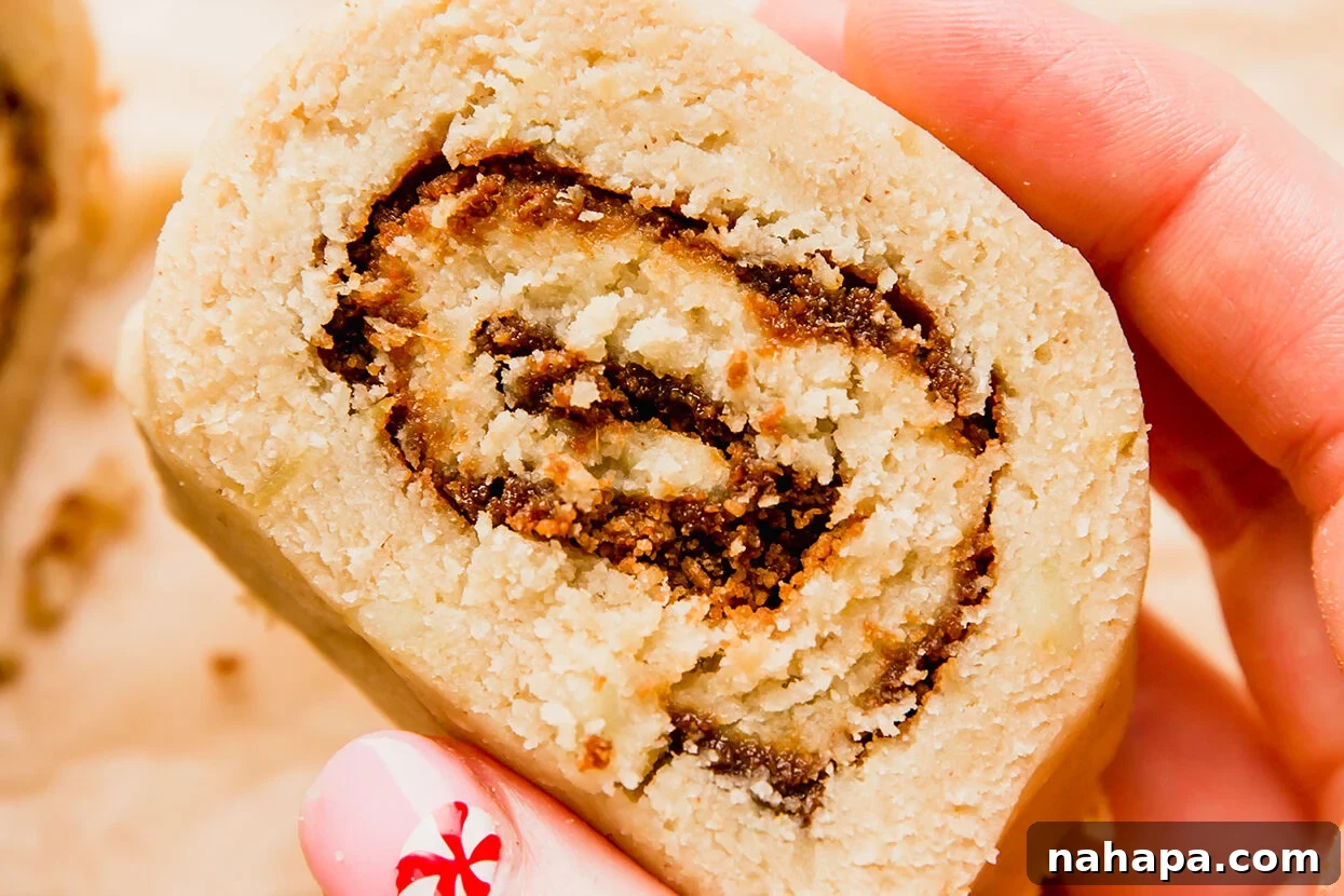 Delicious Gluten Free and AIP Gingerbread Cinnamon Rolls 6 Uncooked gingerbread cinnamon roll being held.