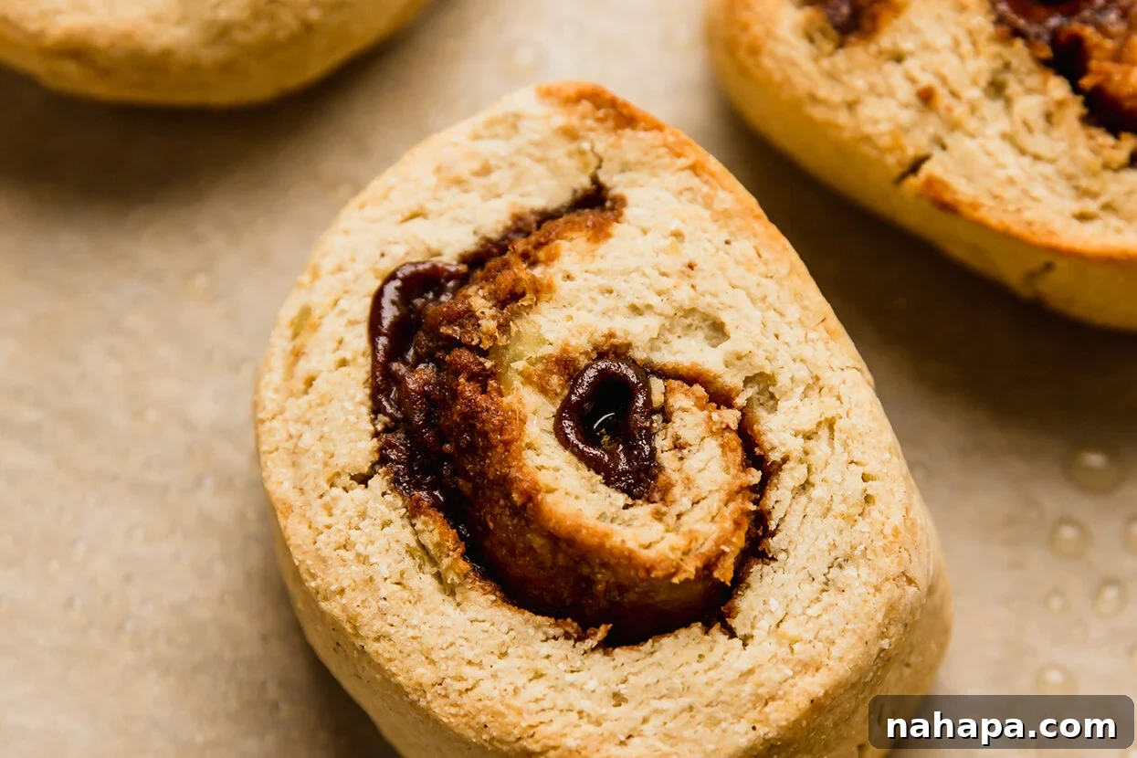 Delicious Gluten Free and AIP Gingerbread Cinnamon Rolls 7 Cooked gingerbread cinnamon rolls on a baking sheet lined with parchment paper.