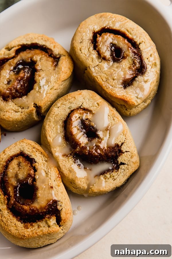 Delicious Gluten Free and AIP Gingerbread Cinnamon Rolls 10 AIP gingerbread cinnamon rolls topped with icing in a baking dish.