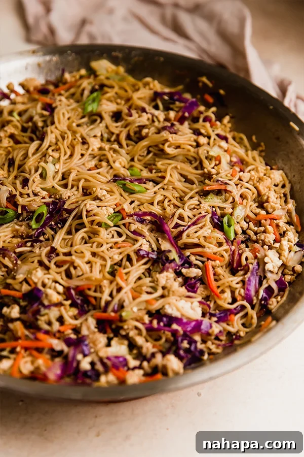 A large skillet filled with the colorful and aromatic egg roll ramen stir fry, ready to be served.