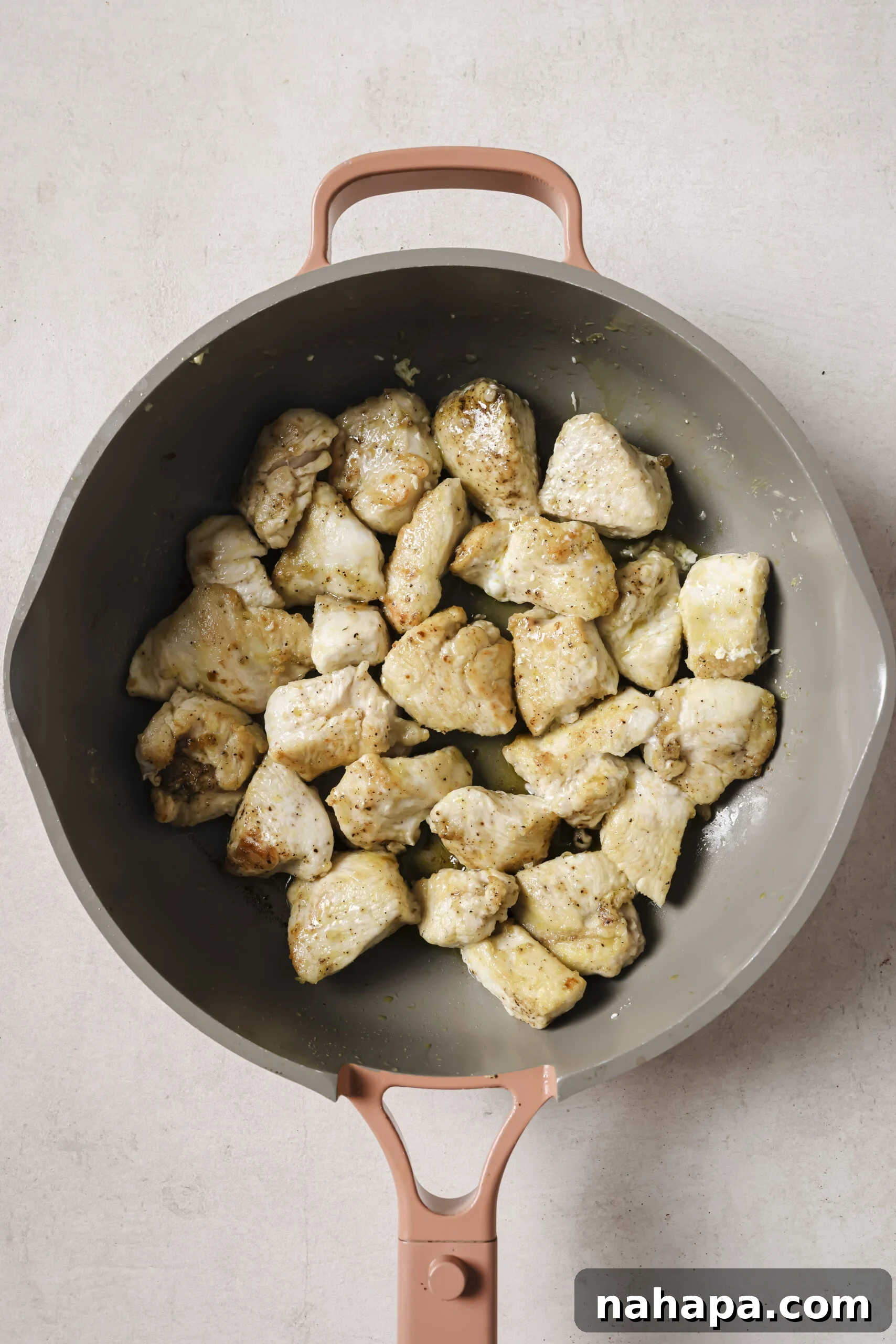 Cooked chicken, cubed in a pan.