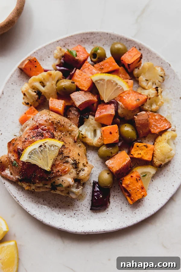 A beautifully plated serving of Sheet Pan Mediterranean Chicken & Vegetables, garnished with fresh herbs.