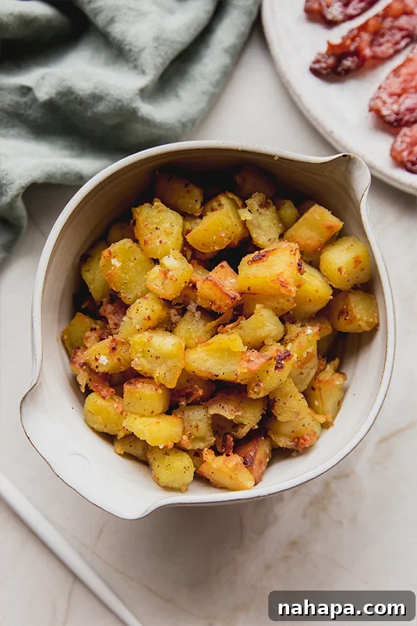 A serving of crispy white sweet potatoes in a bowl, accompanied by perfectly cooked bacon strips on the side, highlighting a delicious meal pairing.