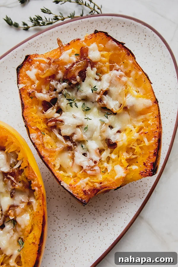A plate with two French onion spaghetti squash boats, garnished with fresh thyme, ready to be enjoyed.