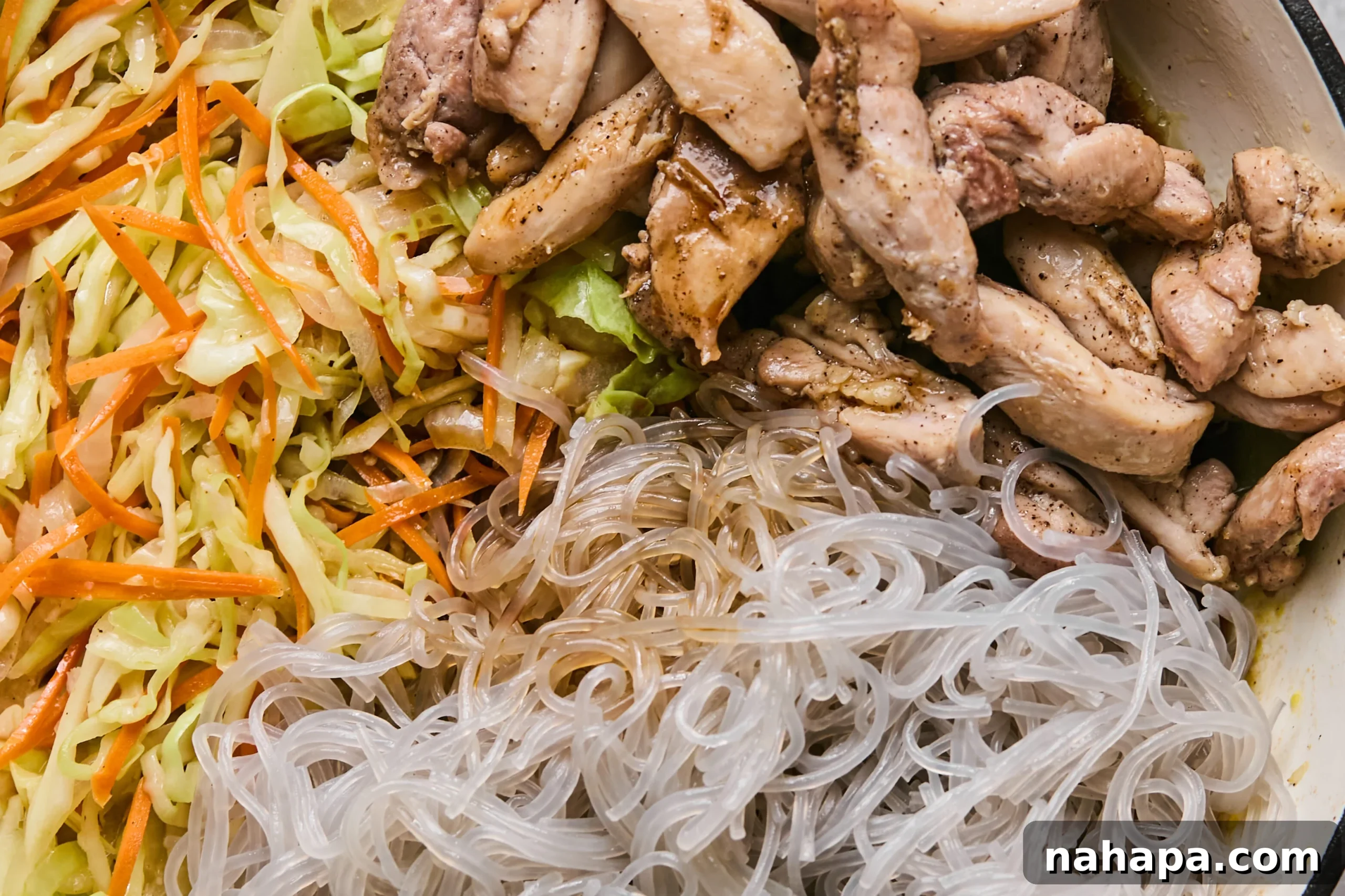 Pad Woon Sen Flavorful Gluten Free Glass Noodle Stir Fry 9 All the stir-fry components, including cooked chicken, softened glass noodles, and vegetables, being tossed with the sauce in a large pan until thoroughly coated.