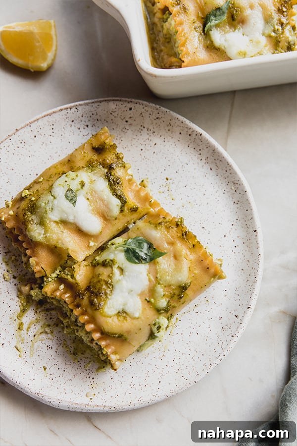 Gluten-Free White Pesto Lasagna Roll-Ups 7 A single serving of white pesto lasagna roll-up plated beautifully, garnished with fresh basil, showcasing its inviting layers and textures.