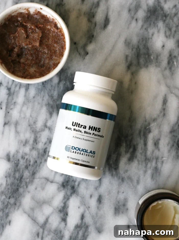 A bottle of Ultra HSN dietary supplements from Douglas Laboratories, placed alongside a small dish of homemade coconut oil and sugar scrub, symbolizing natural beauty and wellness support.
