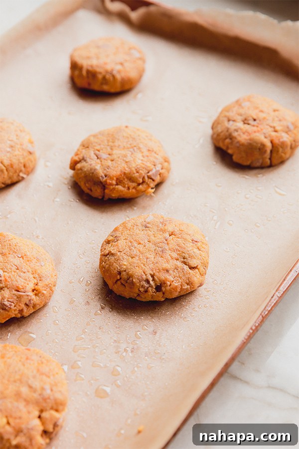 A baking tray filled with perfectly formed sweet potato tuna cakes, ready for the oven.