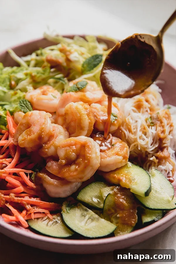 A vibrant Spring Roll Bowl featuring shrimp, noodles, fresh vegetables, and a creamy sauce