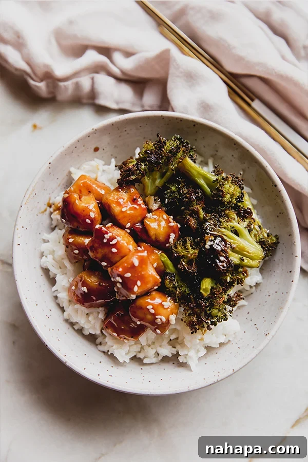 A bowl of sheet pan sesame chicken over rice.