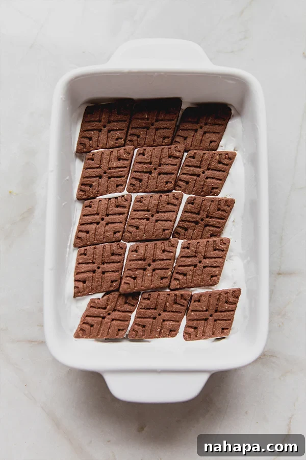 A baking dish with a neat layer of gluten-free cookies covering the bottom, ready for the next step.