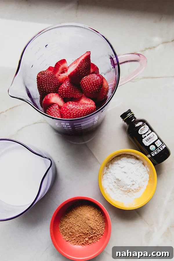 Various whole ingredients for strawberries and cream pudding laid out on a clean surface: fresh strawberries, canned coconut milk, coconut cream, coconut sugar, arrowroot starch, lemon, and vanilla extract.