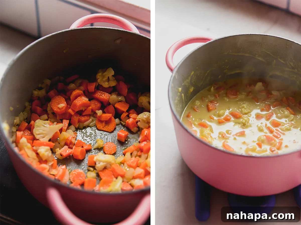 A large pot on a stovetop, filled with vegetables like carrots and cauliflower simmering in a creamy sauce, illustrating the first step of preparing the base for zucchini mac and cheese.